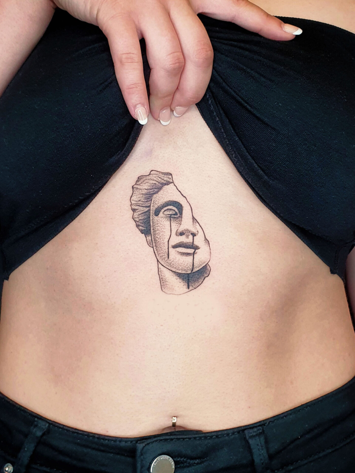 Brusttattoo mit Gesicht