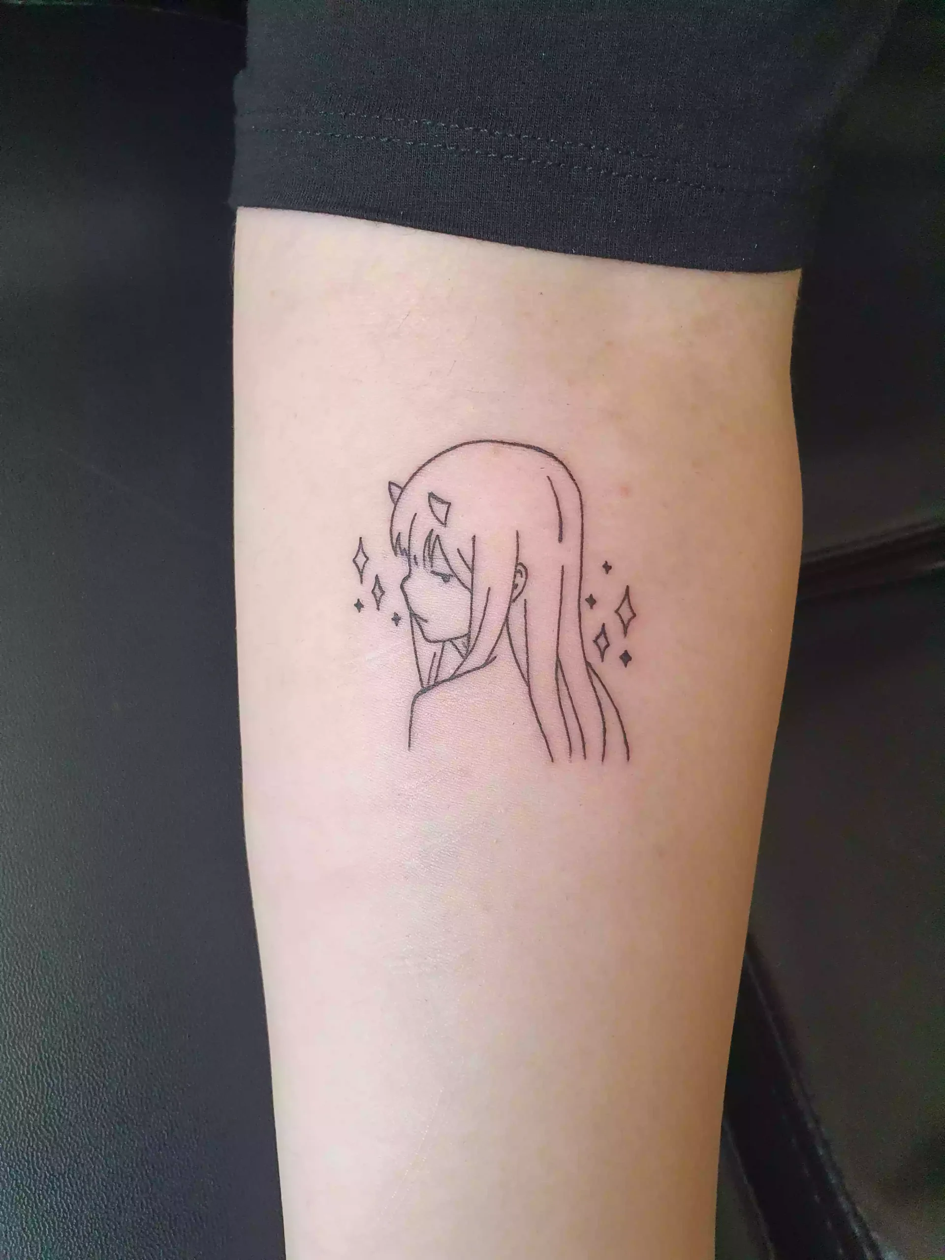 Minimalistisches Anime Portrait Tattoo mit feinen Linien am Unterarm