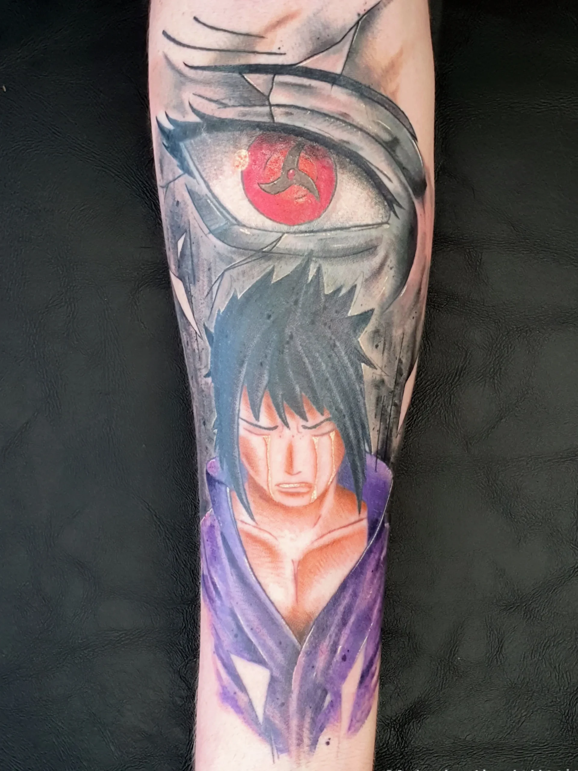 Farbiges Anime Tattoo von Sasuke Uchiha mit Sharingan-Auge am Unterarm