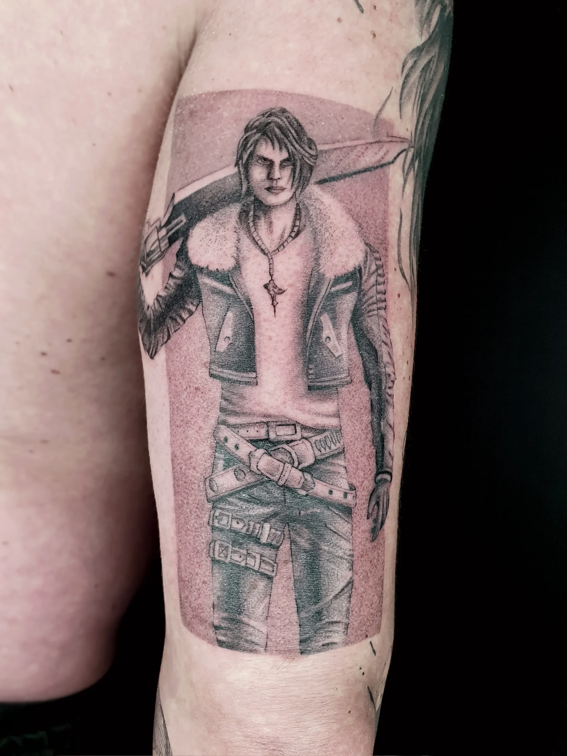 Portrait Tattoo eines Videospiel-Charakters in Schwarz-Grau am Oberarm