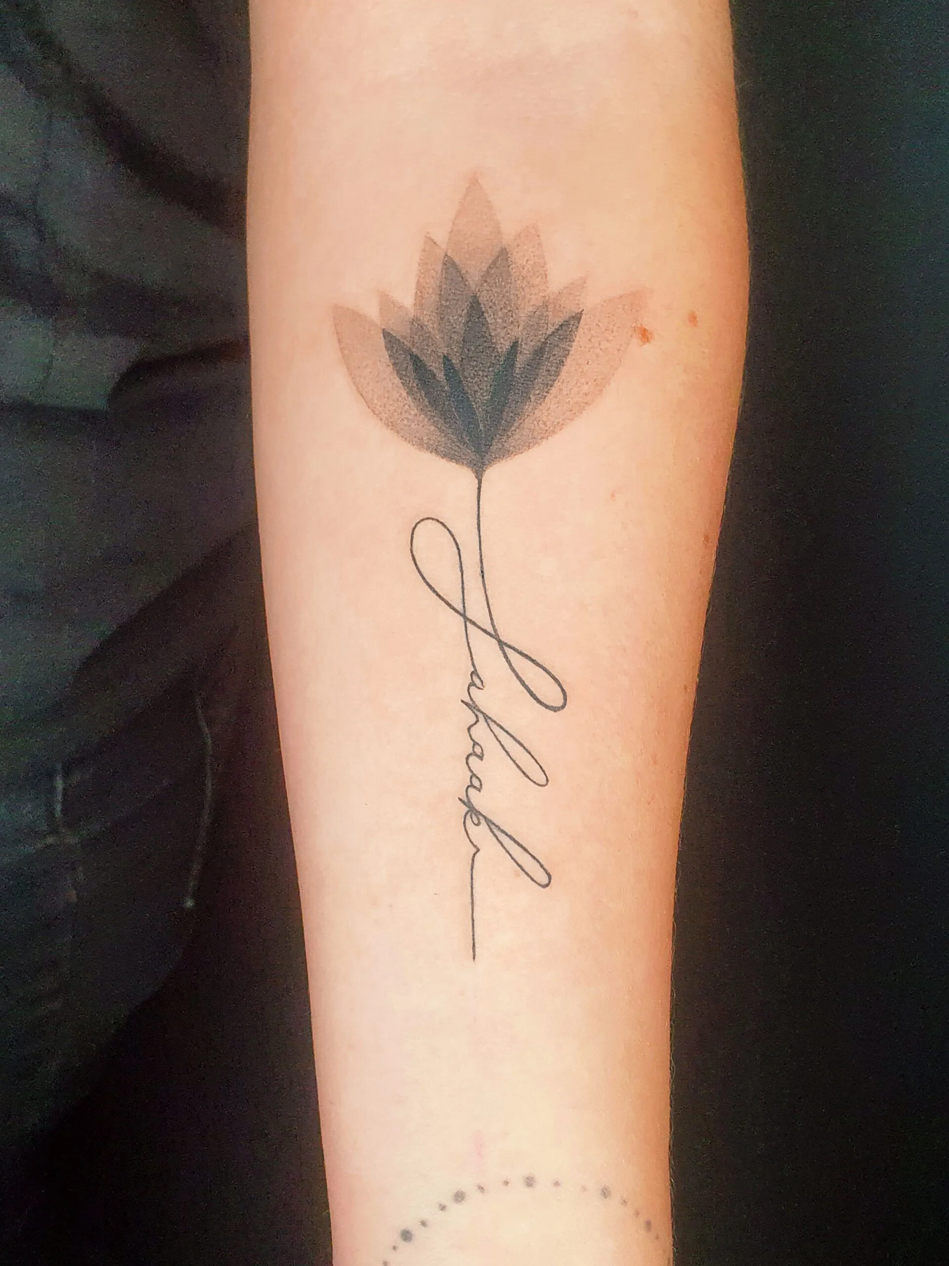 Fineline Tattoo Blume mit feiner Schrift Tattoo auf dem Arm