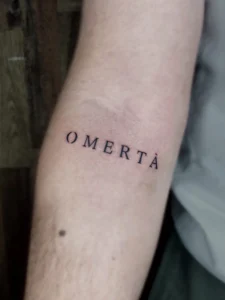 OMERTA Tattoo auf Arm