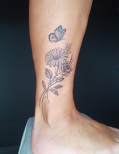 Florales Frauen-Tattoo mit Blütenmotiv im Fineline-Stil
