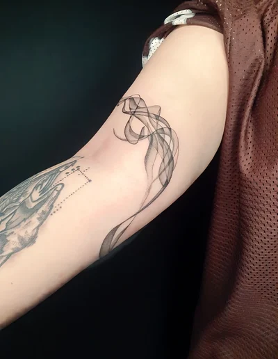 Feines Fineline-Tattoo eines abstrakten Rauchmotivs auf dem Oberarm.