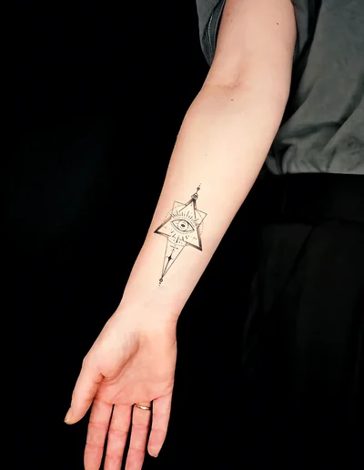 ometrisches Fine Line Tattoo auf dem Unterarm mit Allsehendes Auge in einem Stern, umgeben von klaren Linien und minimalistischen Details.