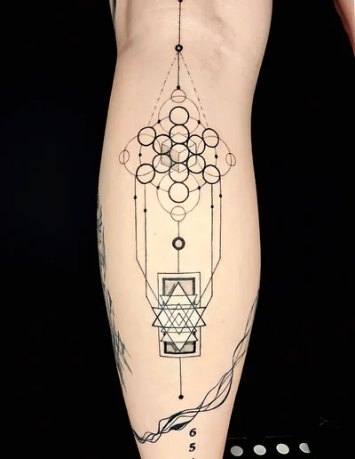 Geometrisches Fine Line Tattoo auf dem Unterschenkel mit symmetrischen Kreisen, Linien und Dreiecken im Stil der heiligen Geometrie