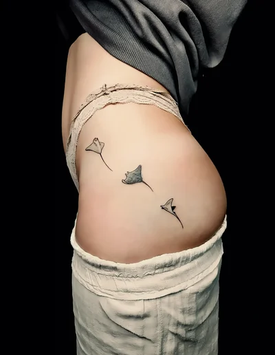 Realistic Tattoo mit drei Rochen auf der Hüfte, fein gestochen und naturgetreu dargestellt.