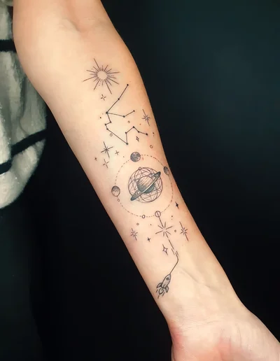 Realistic Tattoo eines Sonnensystems mit Planeten, Sternen, Sternbild und Rakete im Fineline-Stil auf dem Unterarm.
