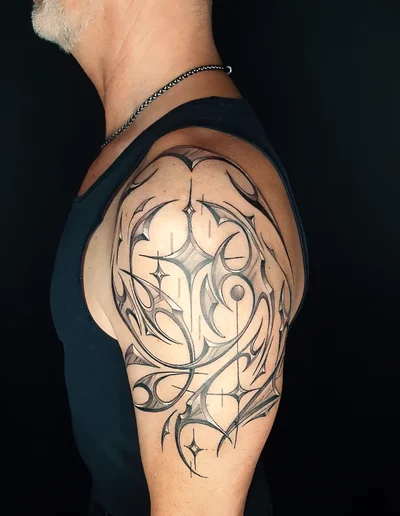 Detailliertes Tribal Tattoo mit abstrakten Linien und Schattierungen auf dem männlichen Oberarm.