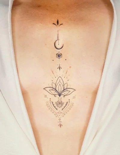 Lotus Tattoo in minimalistischen Stil mit spirituellen Symbolen auf dem Brustbein, gestochen bei EB Tattoo in St. Gallen.