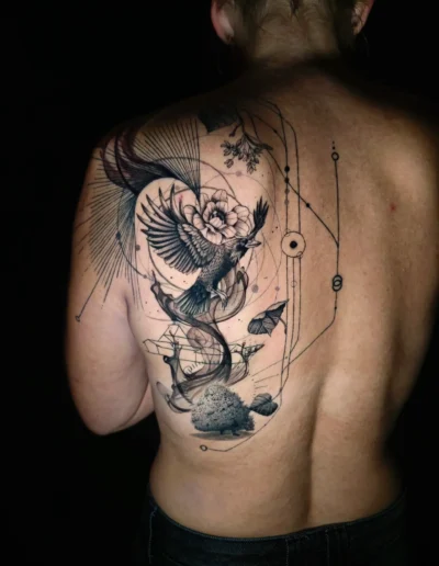 Abstraktes Rücken Tattoo mit Rabe, Blume, geometrischen Linien und Baum bei EB-Tattoo in St. Gallen