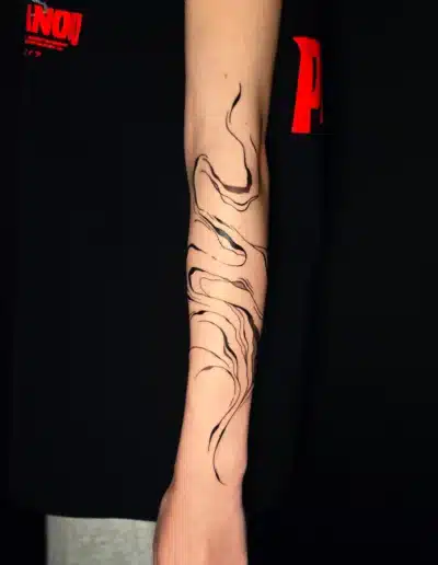 Abstract Linework Tattoo mit fliessenden, organischen Linien am Unterarm, gestochen bei EB-Tattoo St. Gallen