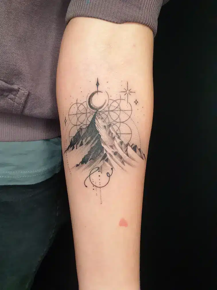 Geometrisches Berg Tattoo im Fineline-Stil mit Mond und Ornamenten am Unterarm bei EB-Tattoo St. Gallen