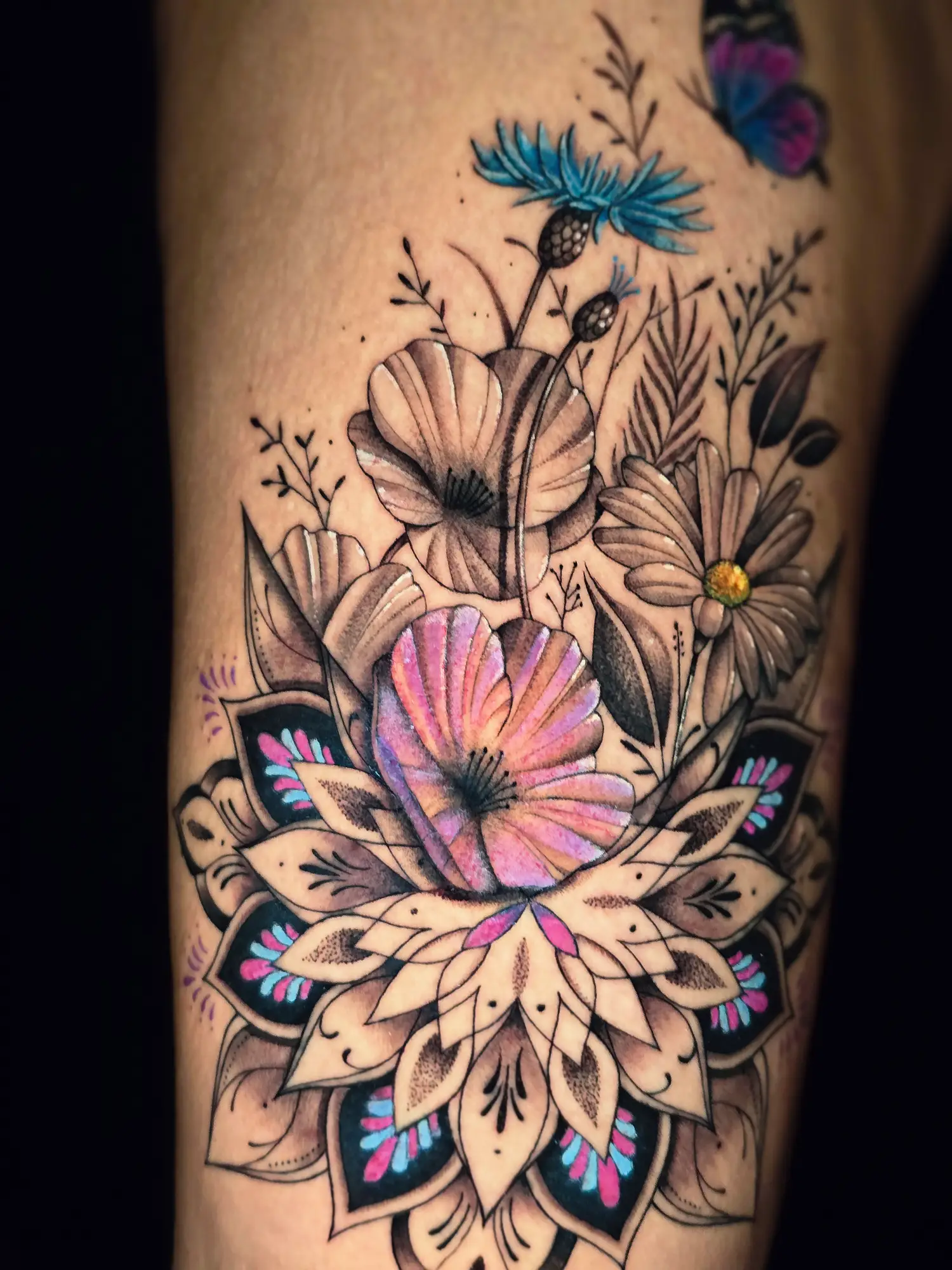 Detailaufnahme eines farbigen Blumen-Mandala Tattoos mit Blüten und Ornamenten