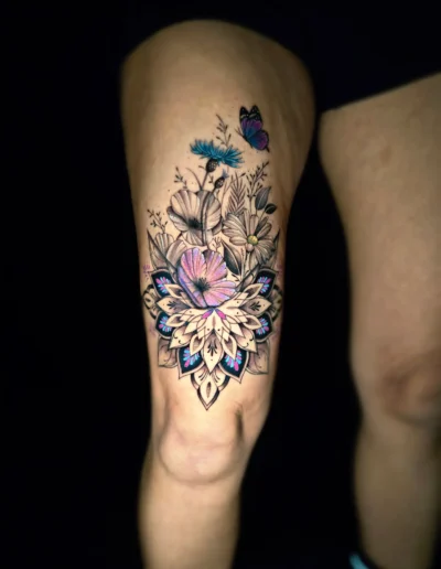 Farbiges Blumen-Mandala Oberschenkel Tattoo mit Schmetterling bei EB-Tattoo St. Gallen