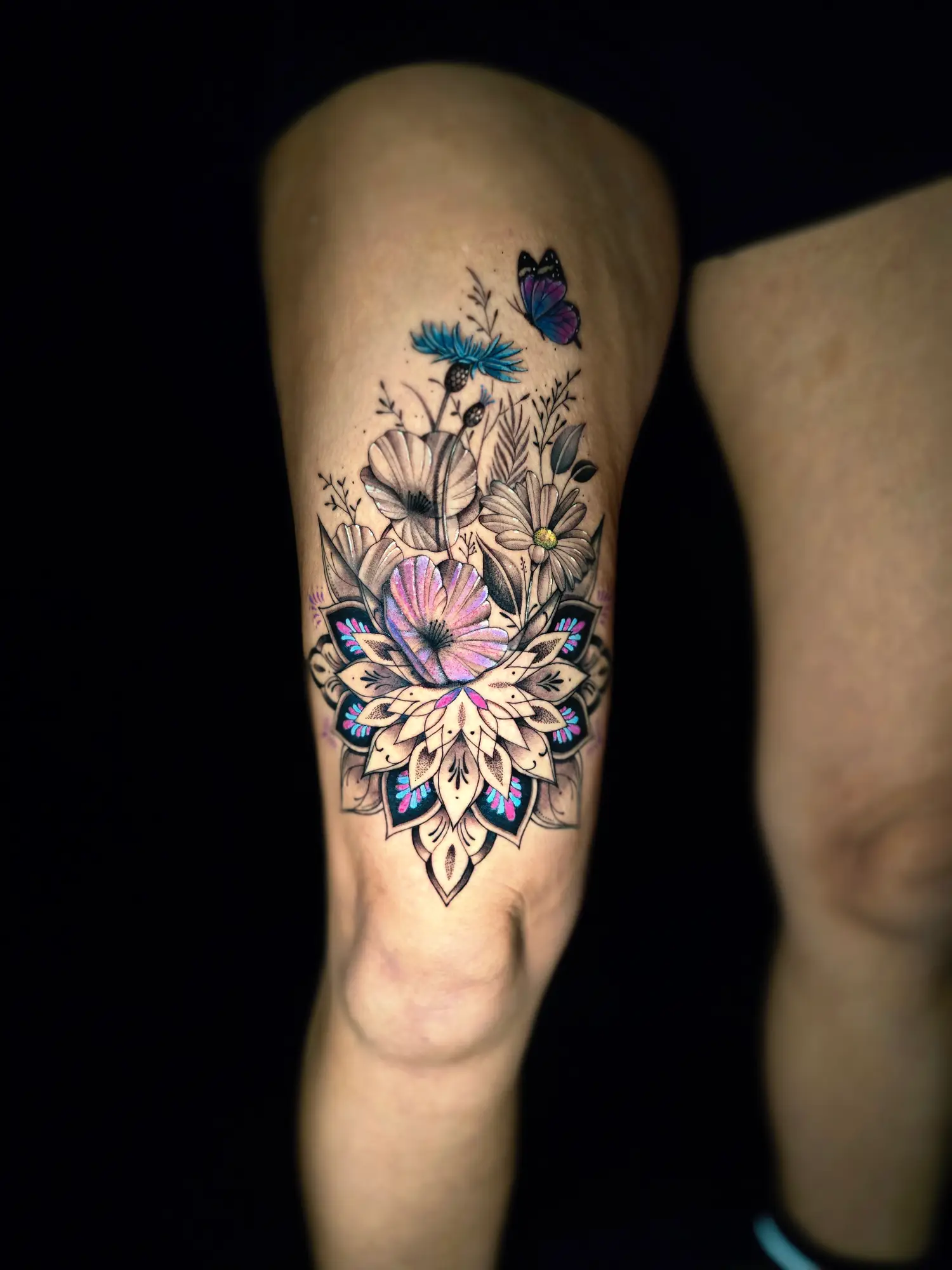 Farbiges Blumen-Mandala Tattoo mit Schmetterling am Oberschenkel