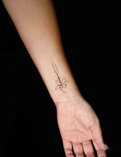 Fine Line Blumen Tattoo mit feiner Linienführung am Handgelenk, gestochen bei EB-Tattoo St. Gallen