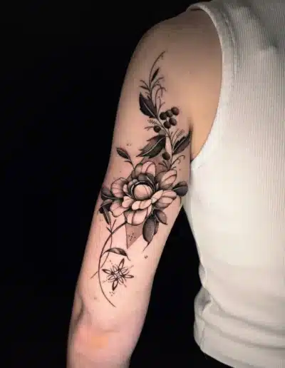 Realistisches Blumen-Tattoo mit Blättern und Beeren am Oberarm bei EB-Tattoo St. Gallen