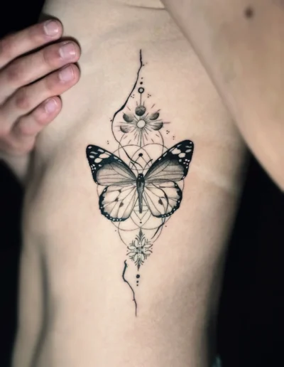 Fineline Schmetterling Tattoo mit geometrischen Elementen an den Rippen bei EB-Tattoo St. Gallen