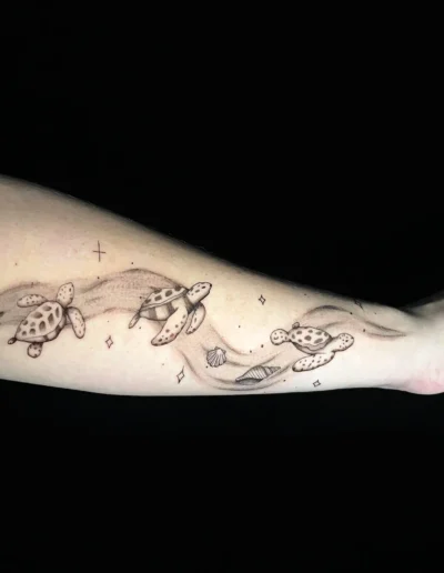 Fineline Unterarm-Tattoo mit mehreren Meeresschildkröten und Wellen bei EB-Tattoo St. Gallen