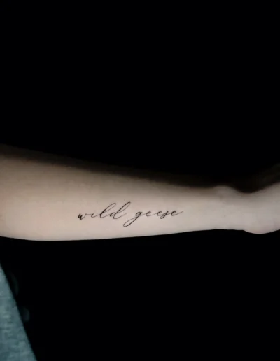 Minimalistisches Script Lettering Tattoo „wild geese“ am Unterarm bei EB-Tattoo St. Gallen