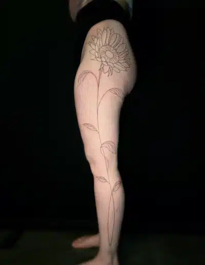 Großes Fineline Sonnenblumen Tattoo über Oberschenkel und Bein bei EB-Tattoo St. Gallen