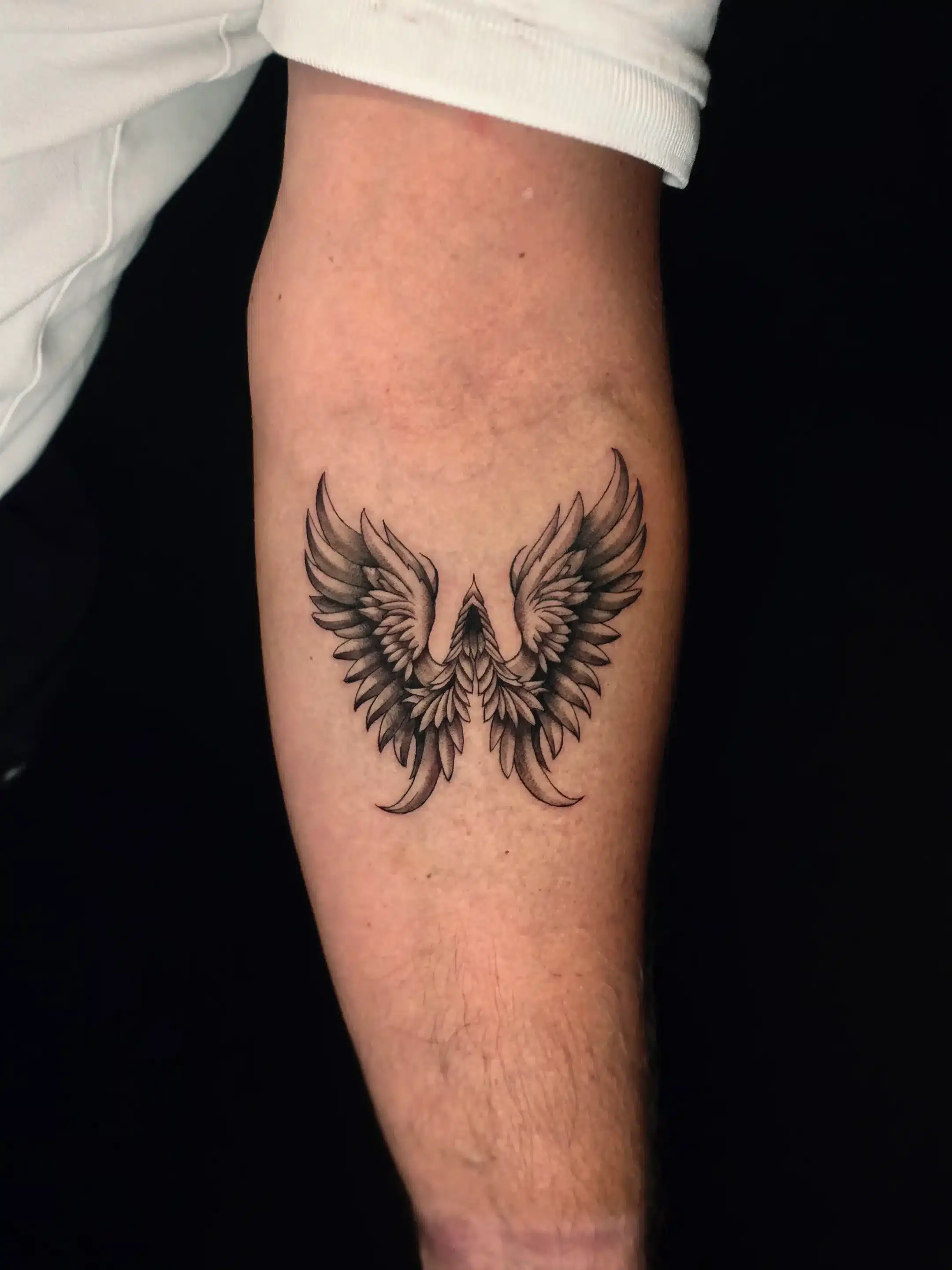 Fein schattiertes Engelsflügel Tattoo am Unterarm – EB Tattoo St. Gallen