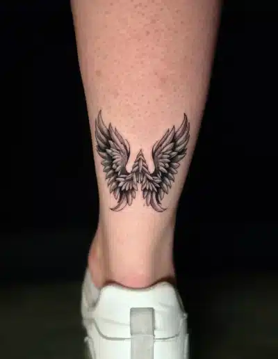 Fein schattiertes Flügel Tattoo am Unterschenkel, symmetrisch und detailreich, gestochen bei EB-Tattoo St. Gallen