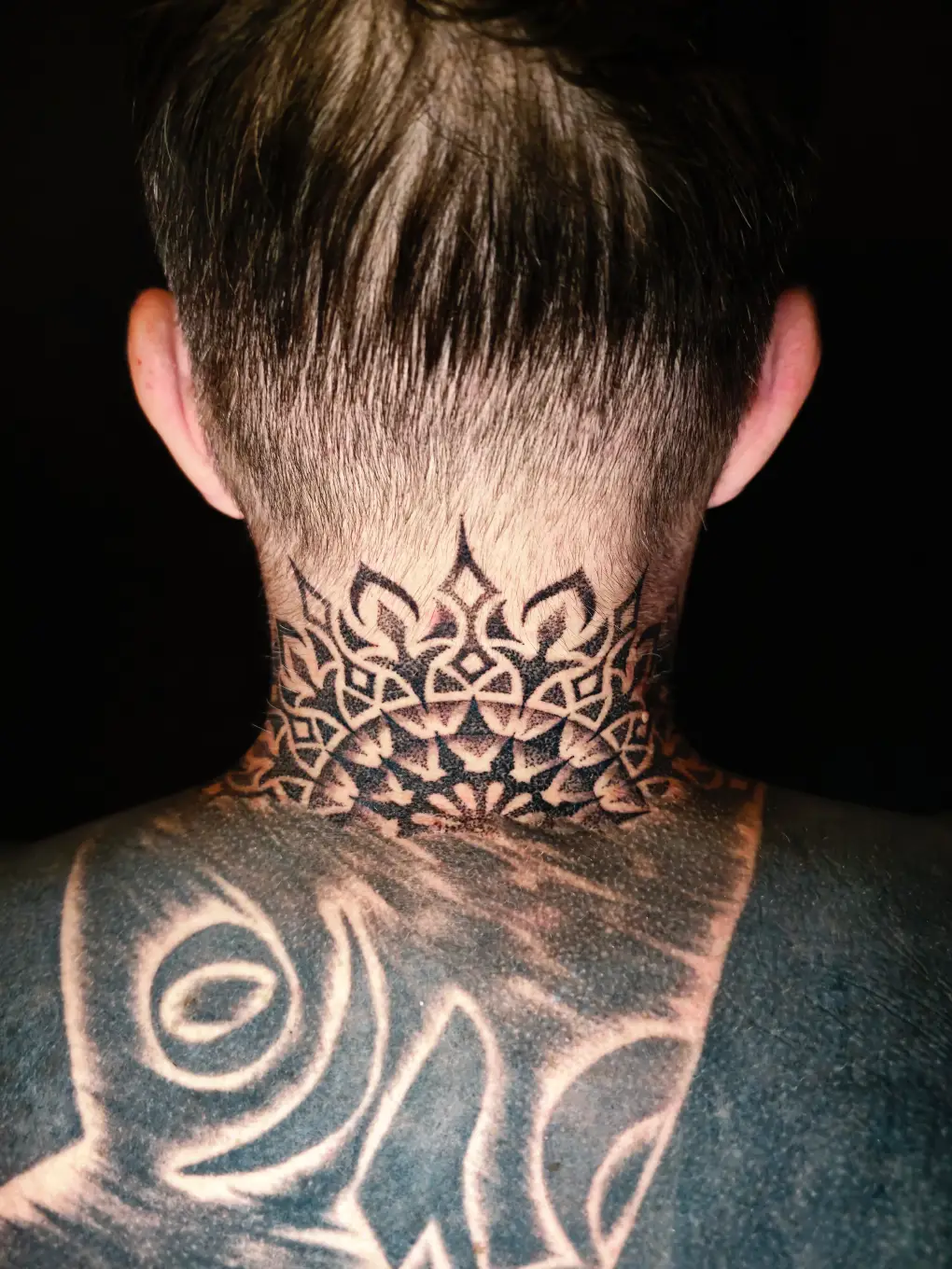 Geometrisches Dotwork Tattoo am Nacken mit symmetrischen Mustern bei EB-Tattoo St. Gallen