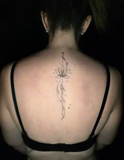 Feines Lotus Wirbelsaeulen Tattoo im Lineart Stil bei EB-Tattoo St. Gallen