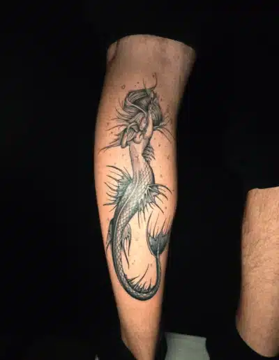 Schwarzgraues Meerjungfrau Tattoo am Unterschenkel eines Mannes, gestochen bei EB-Tattoo St. Gallen