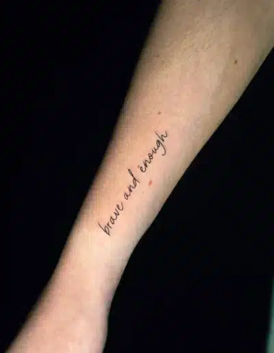 Minimalistisches Schriftzug Tattoo „brave and enough“ am Unterarm, gestochen bei EB-Tattoo St. Gallen