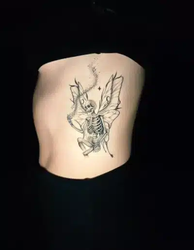 Lineart Skelett Fee Tattoo am Rippenbogen bei EB-Tattoo St. Gallen