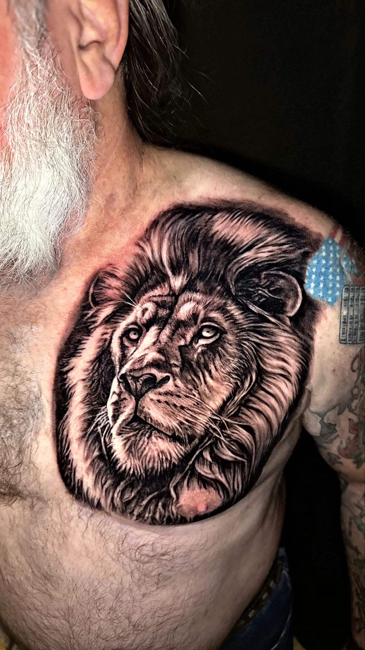 Realistisches Löwenportrait Tattoo in Black and Grey auf der Brust, gestochen von Alessandro bei EB Tattoo St. Gallen