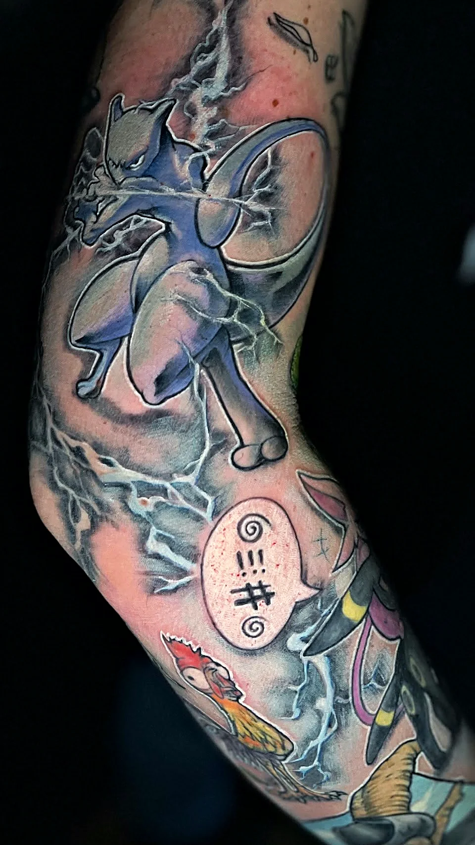 Farbiger Comic Sleeve mit Anime-Charakteren und Blitz-Effekten, gestochen von Jens bei EB Tattoo St. Gallen